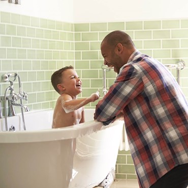 Man bathing his son in a clean bathroom